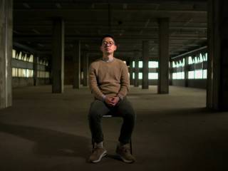 nathan law sedící na židli v prázdné hale