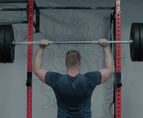 muž zezadu, visící na hrazdě ve vzpěru