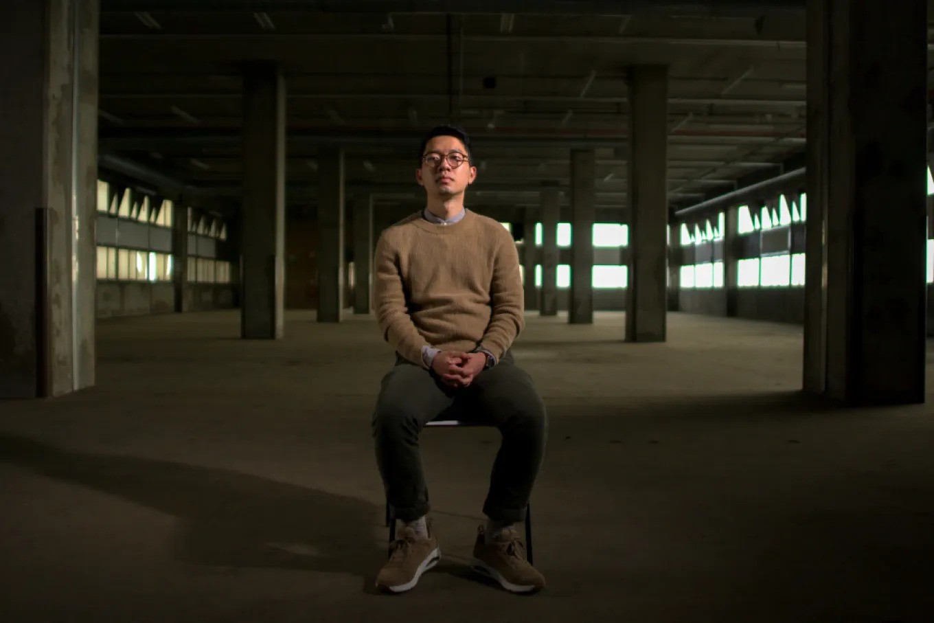 nathan law sedící na židli v prázdné hale